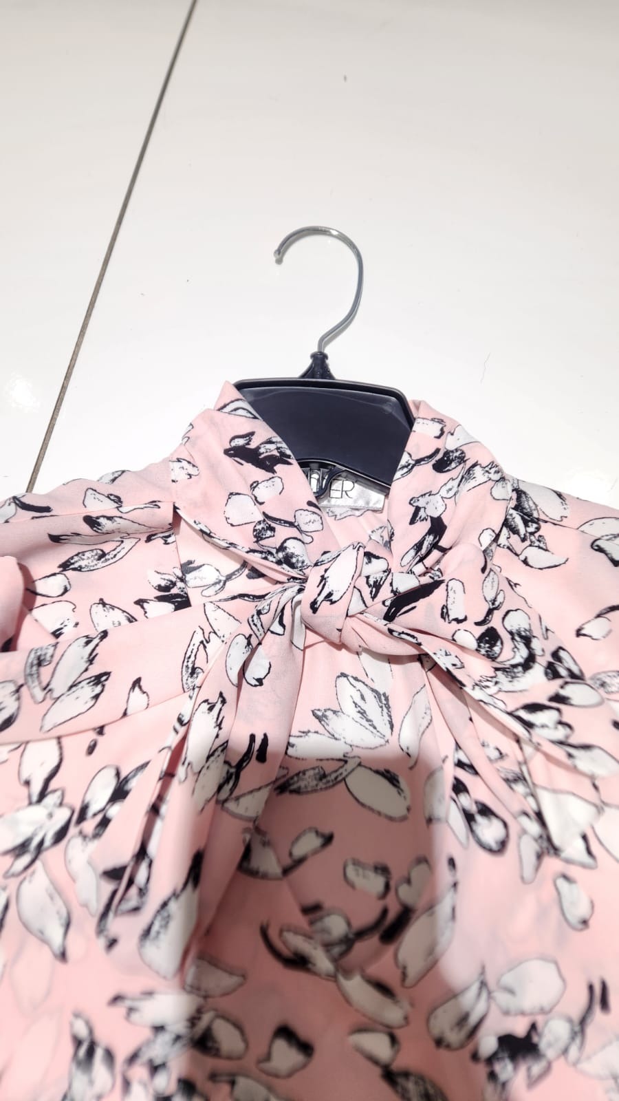 Detalle real de Blusa floral rosa con lazo